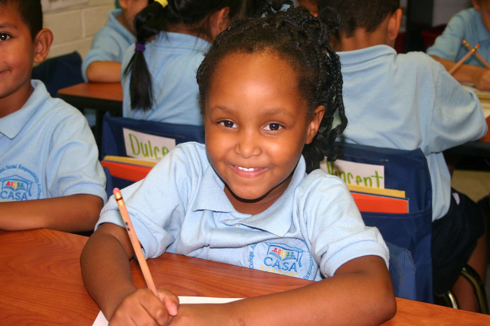 Smiling CASA scholar holding a pencil