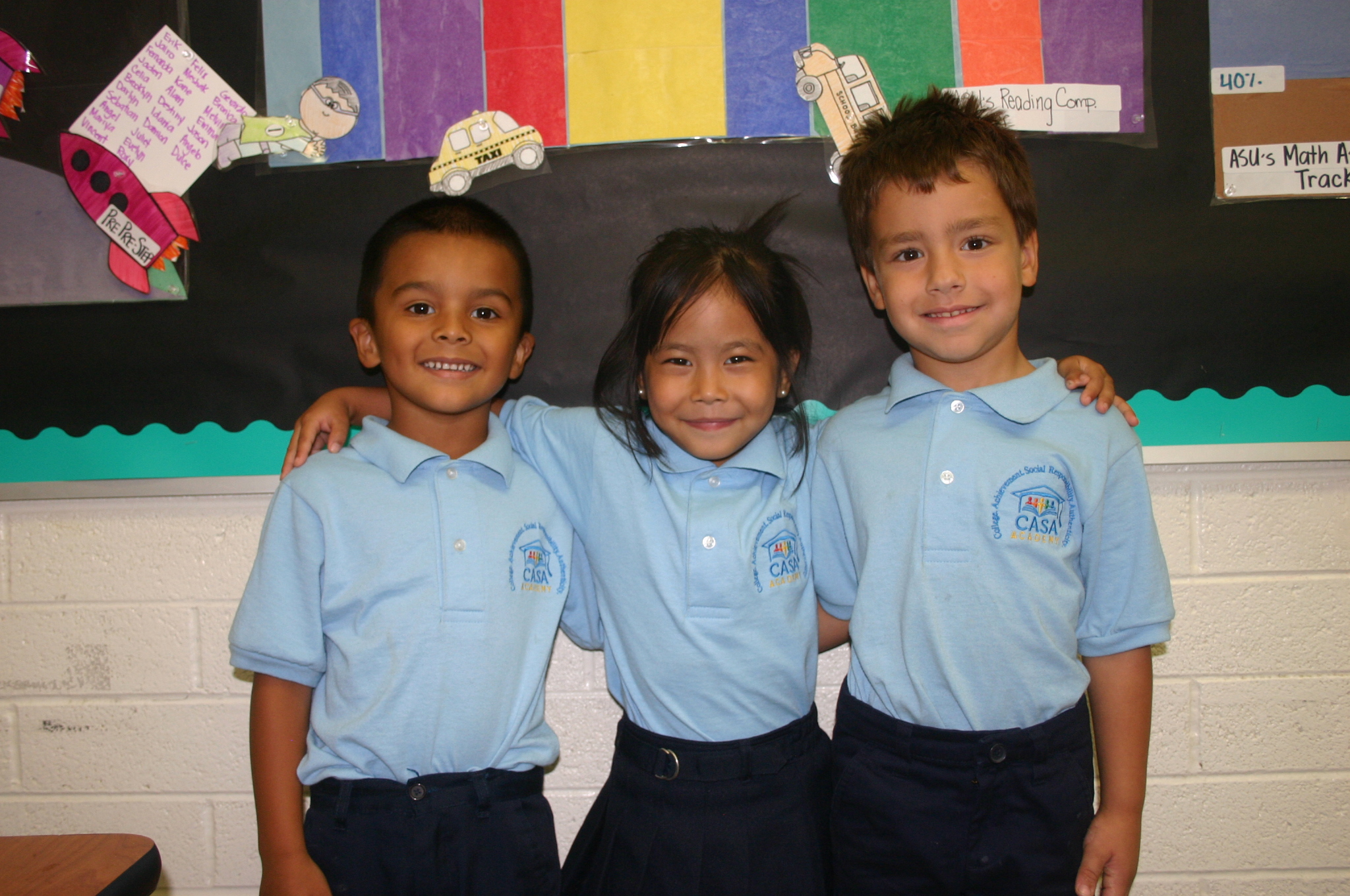 3 CASA Academy scholars smile in a classroom