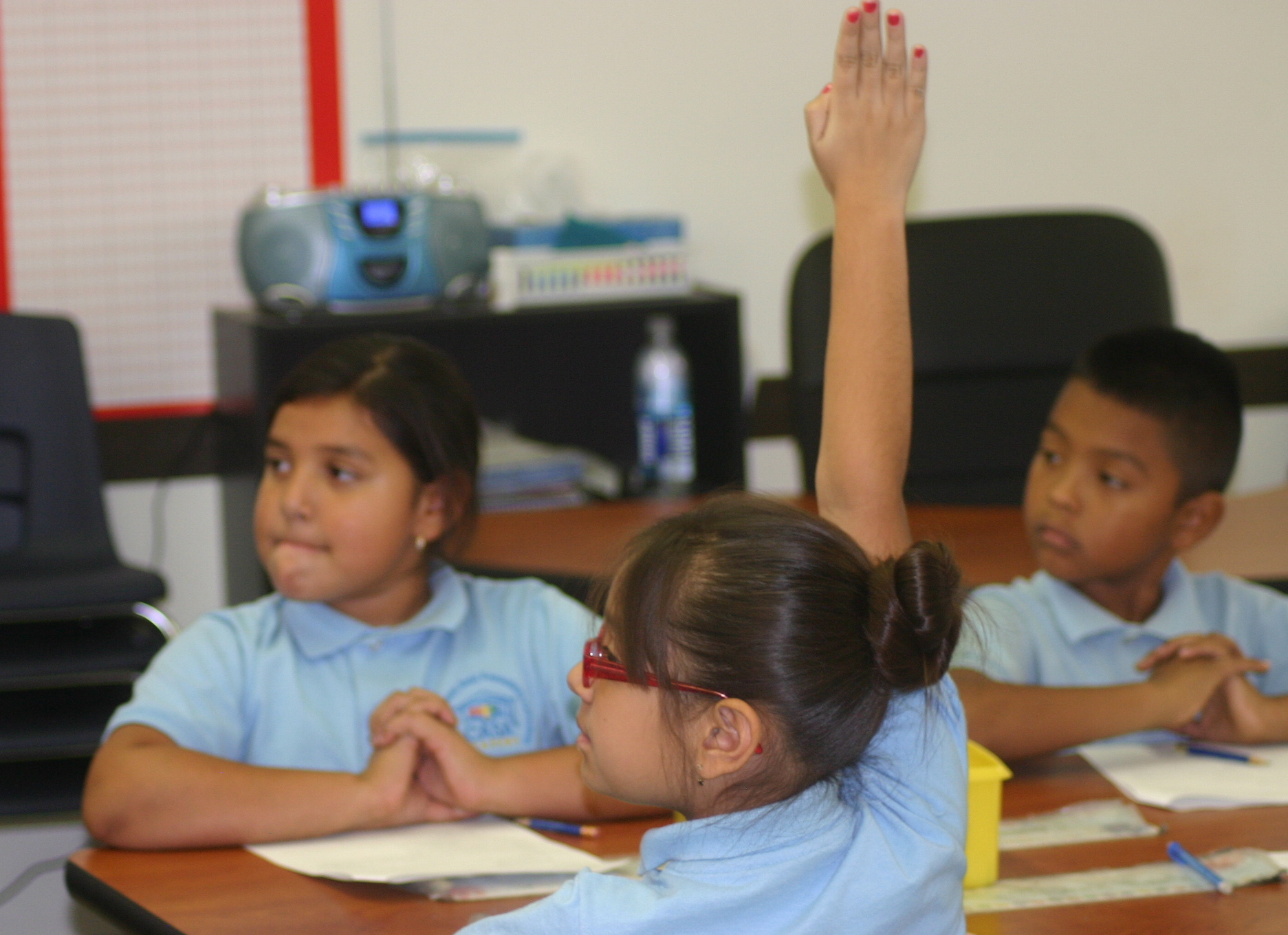 A CASA Academy scholar raises her hand in the classroom