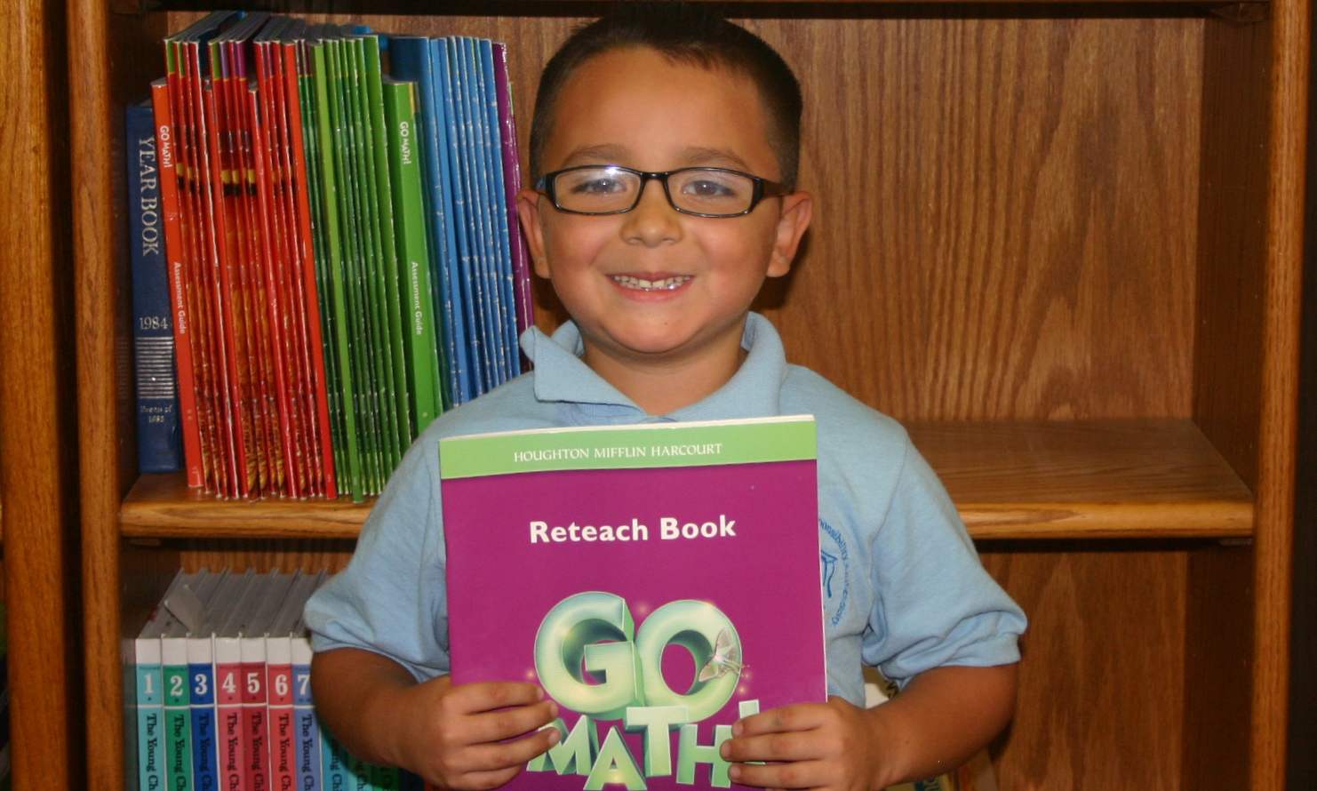 A CASA Academy scholar displays the math book from our curriculum.