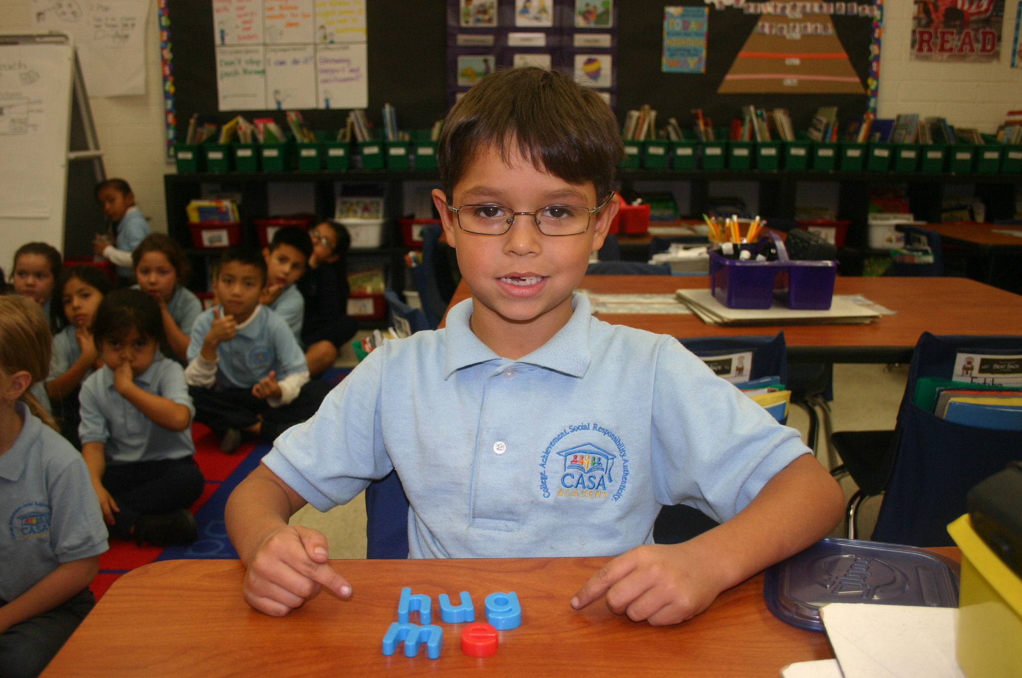 A CASA Academy scholar uses tools on his desk during a lesson.