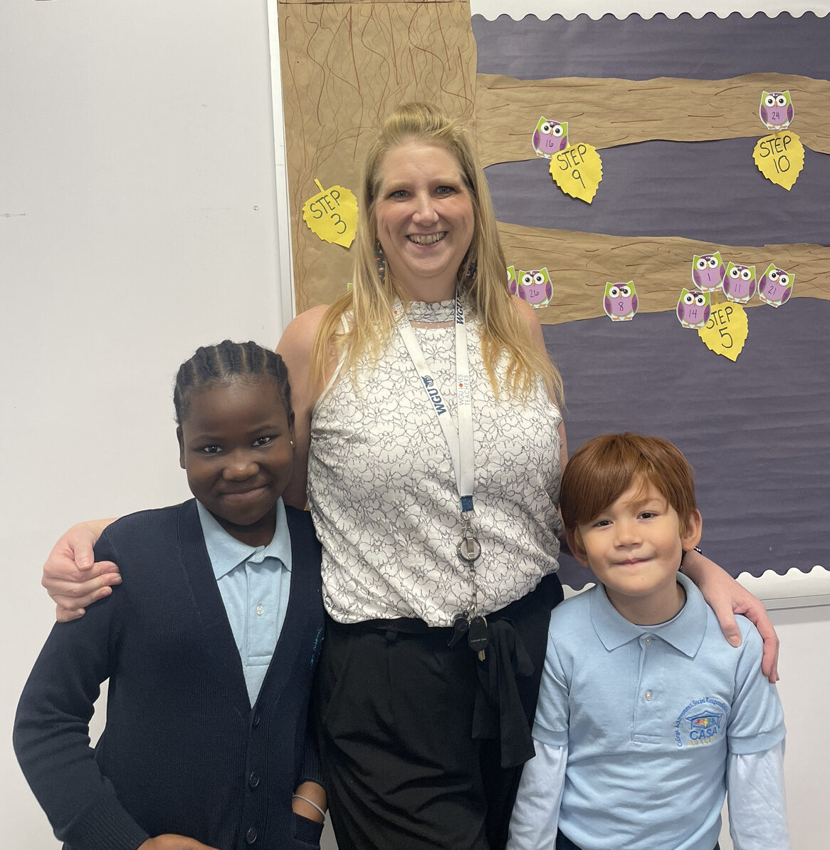 CASA Academy teacher, Amy Curtiss, smiles with 2 students