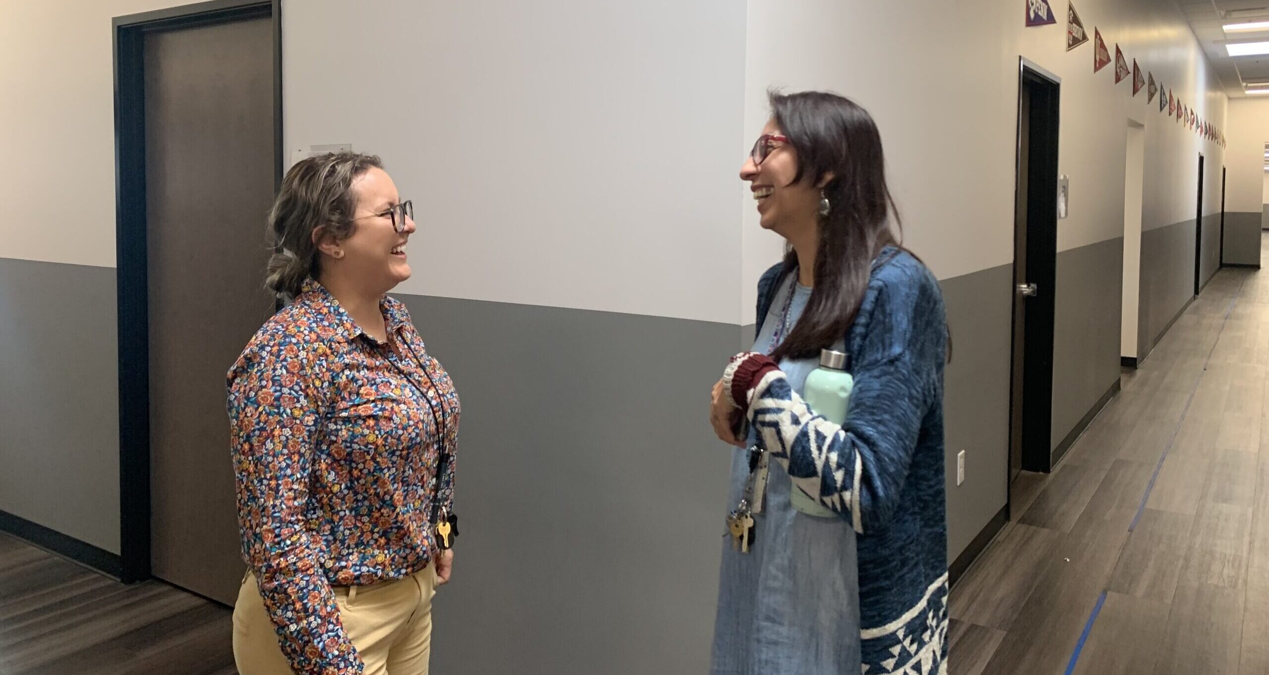 Two CASA Academy teachers meet in the hallway