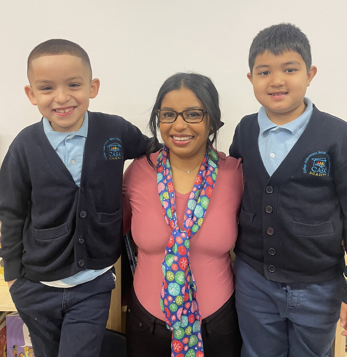 CASA Academy teacher Maritza Bermudez smiles with 2 students.