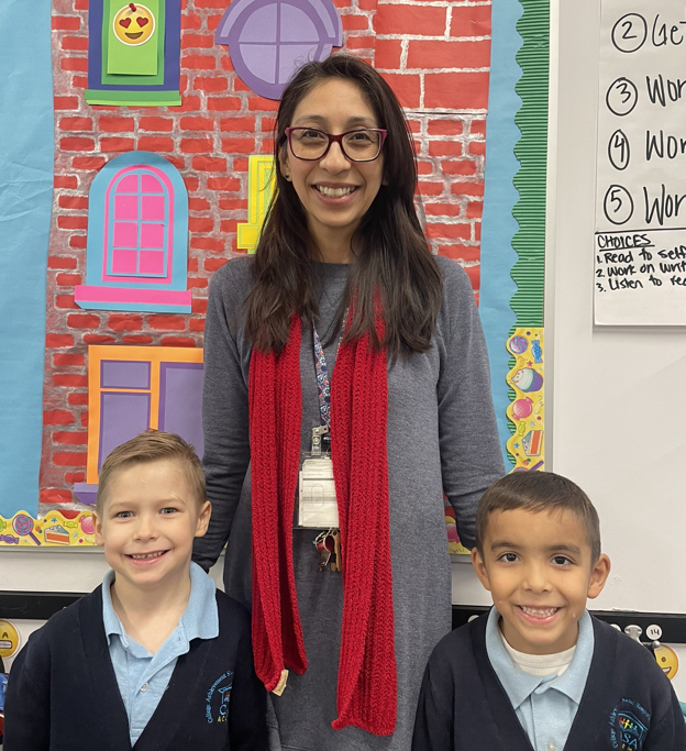 Mirella Rivera, a CASA Academy teacher, smiles with 2 students. 