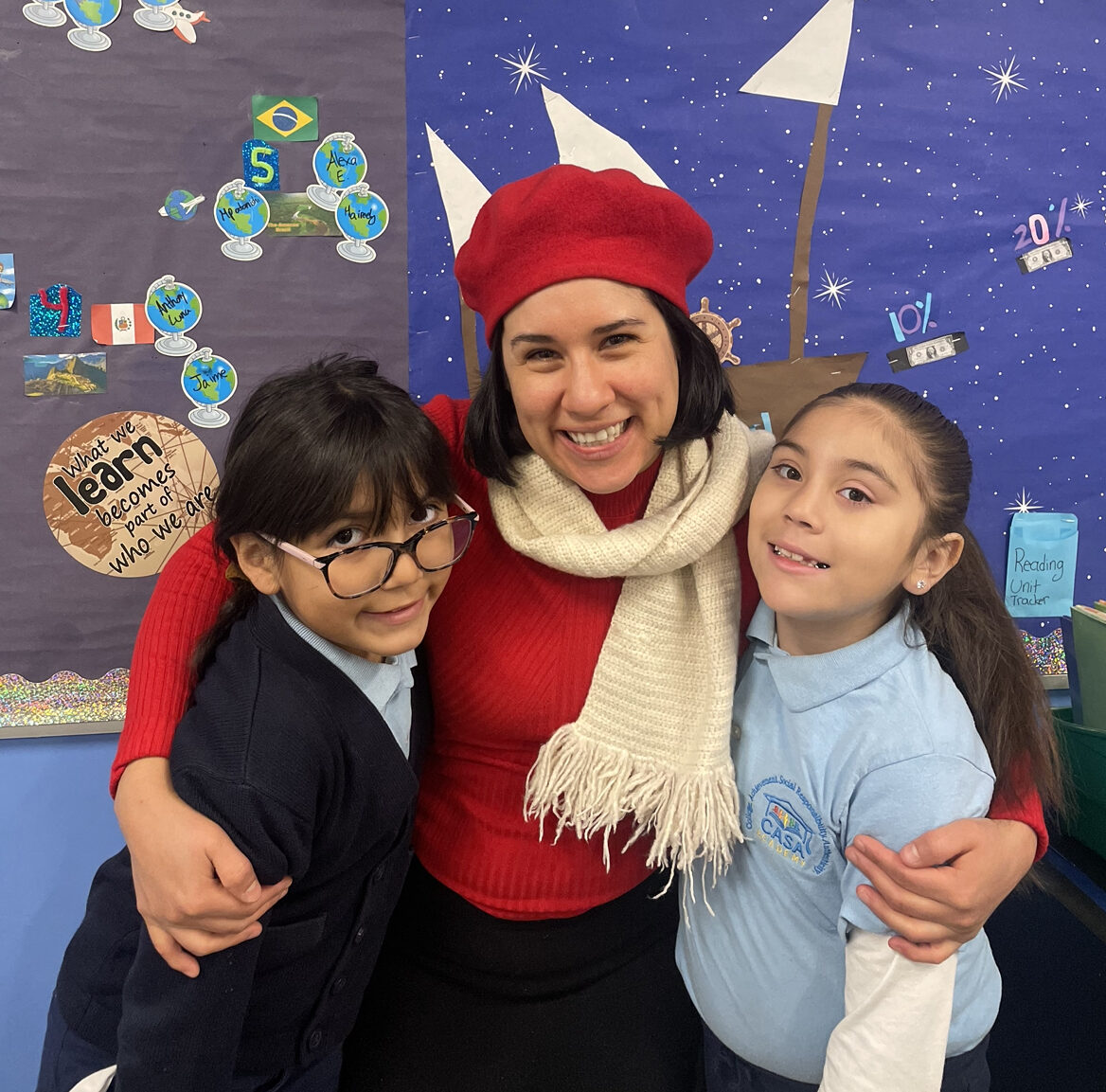 CASA Academy teacher, Pamela Prieto, smiles with 2 students