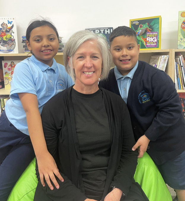 CASA Academy teacher, Robin Miller, smiles with 2 students