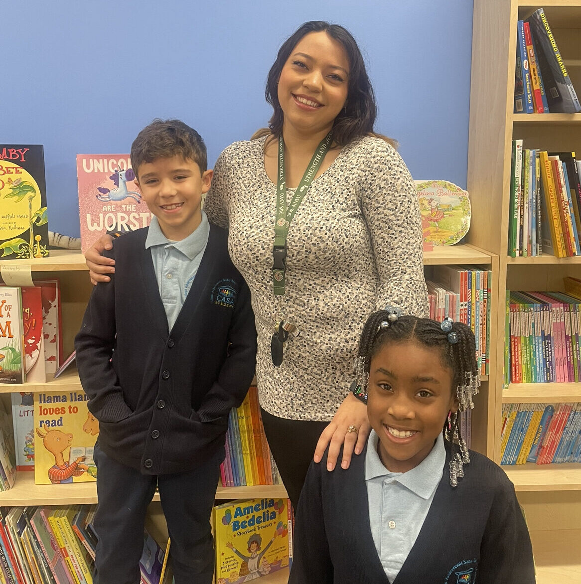 Tanya Gomez, a CASA Academy teacher, smiles with 2 students. 